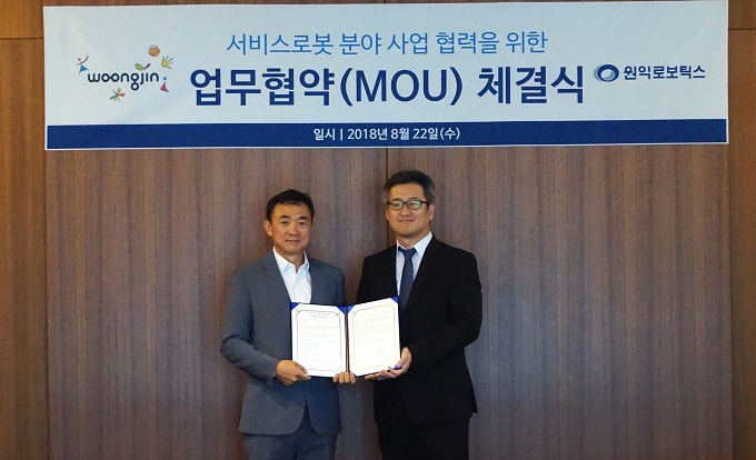Wonik Robotics CEO Kyung-seok Jang (left) and Woongjin CEO Suyoung Lee (right) pose for a commemorative photo after signing a Memorandum of Understanding (MOU) on cooperation in the robot service business at Wonik Robotics headquarters on August 22.